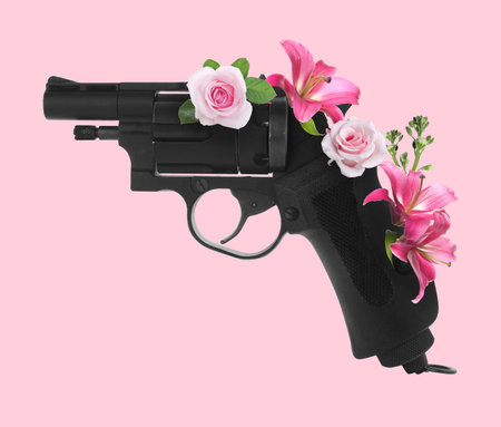 Gun with flowers on pink background. Stop violence, make peace