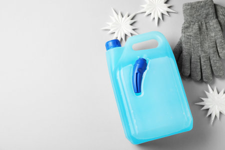 Antifreeze, gloves and winter decor on light grey background, flat lay. Space for textの写真素材