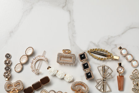 Beautiful hair clips on white marble table, flat lay. Space for text