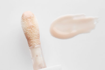 Lip balm and applicator on white background, top view