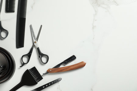 Many different barber's tools on white marble table, flat lay. Space for textの写真素材