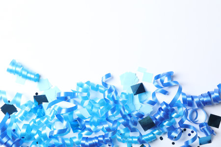 Blue serpentine streamers and confetti on white background, top viewの写真素材