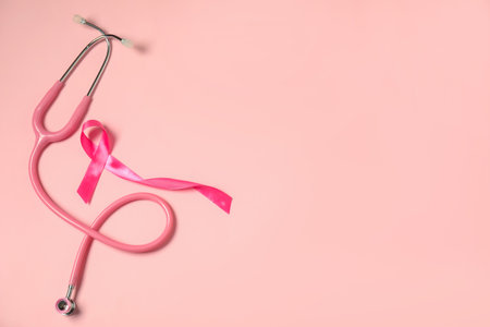Breast cancer awareness. Pink ribbon and stethoscope on color background, flat lay. Space for textの写真素材