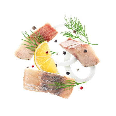 Pieces of herring, lemon, onion, dill and peppers mix in air on white background