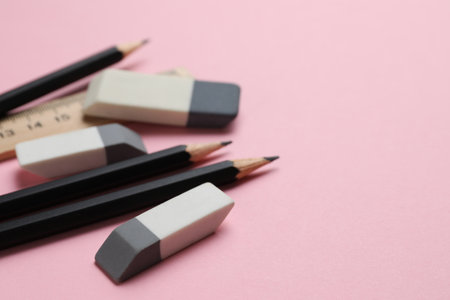 Erasers, ruler and pencils on pink background, closeup. Space for textの写真素材