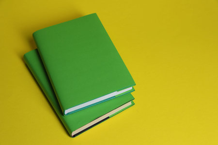 Two color books on yellow background, above view. Space for textの写真素材
