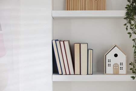 Different books and decor on shelves indoorsの写真素材