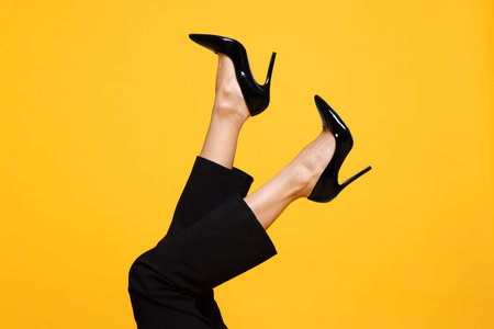 Woman wearing stylish high heeled shoes on orange background, closeup