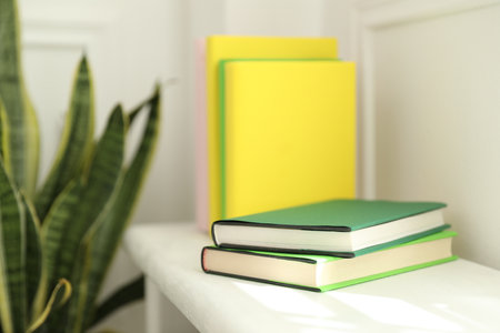 Many colorful books on white shelf indoorsの写真素材