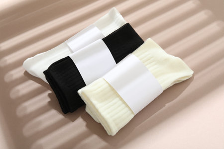 Many different pairs of socks on beige background with shadow