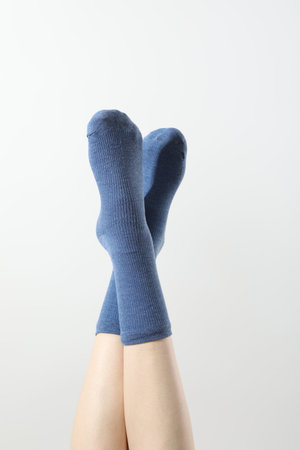 Woman in blue socks on light background, closeupの写真素材