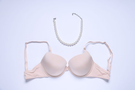 Pink bra and necklace on white background, flat layの写真素材