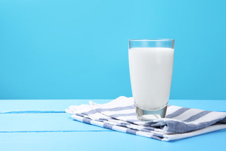 Fresh milk in glass on light blue wooden table. Space for textの写真素材