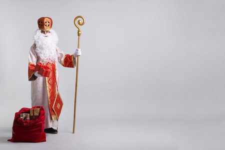 Saint Nicholas with sack full of gifts on light grey background. Space for textの写真素材