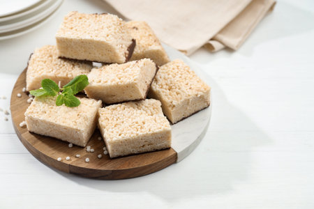 Delicious puffed rice bars and mint on white wooden table, closeup. Space for textの写真素材