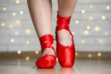 Ballerina dancing in pointe shoes against blurred lights, closeup. Bokeh effectの写真素材