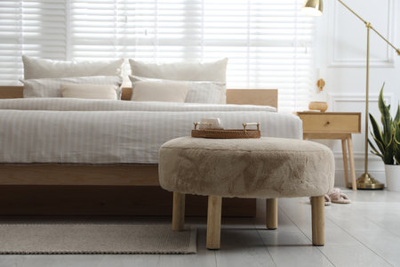 Pouf near comfortable bed in stylish room. Interior designの写真素材