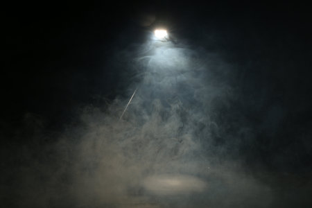 Beautiful smoke in lights on dark backgroundの写真素材