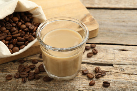 Coffee cream in glass and beans on wooden table, closeupの写真素材