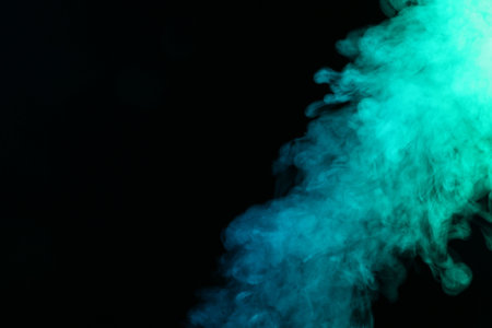 Beautiful smoke in neon lights on dark background, space for textの写真素材