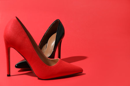 High heeled shoes on crimson background, space for textの写真素材