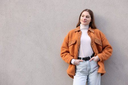 Portrait of beautiful teenage girl near gray wall, space for textの写真素材