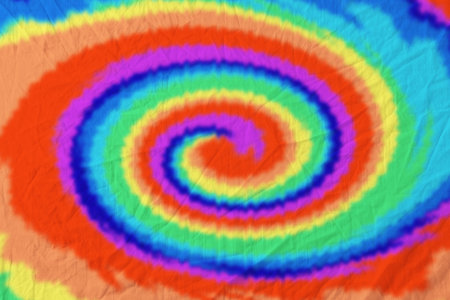 Bright fabric dyed with tie-dye technique. Textile with swirls in rainbow colorsの写真素材