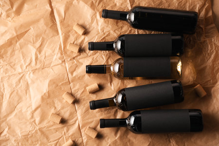 Bottles of wine and corks on parchment paper, flat lay. Space for textの写真素材