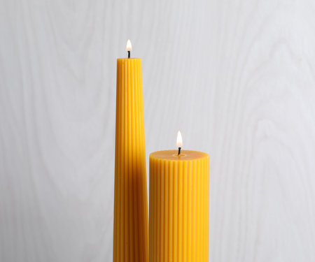 Burning beeswax candles on light background, closeupの写真素材