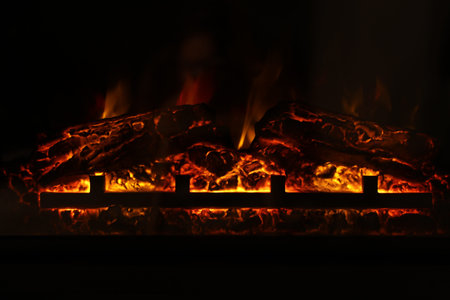 Firewood burning bright in elegant fireplace indoors, closeup