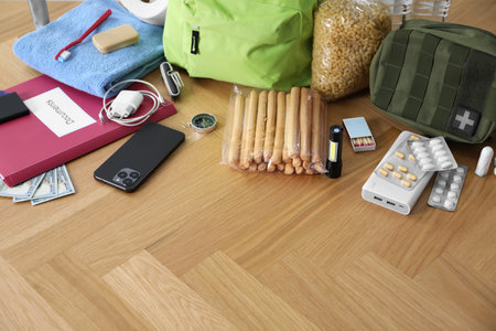 Survival kit. Different emergency supplies on wooden table indoors, space for text