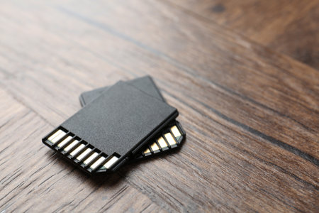 Two SD memory cards on wooden table, closeup. Space for textの写真素材