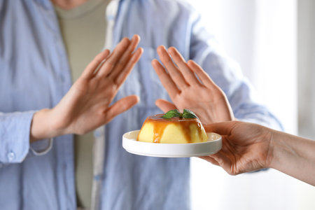 Woman refusing pudding indoors, selective focus. Food allergy conceptの写真素材