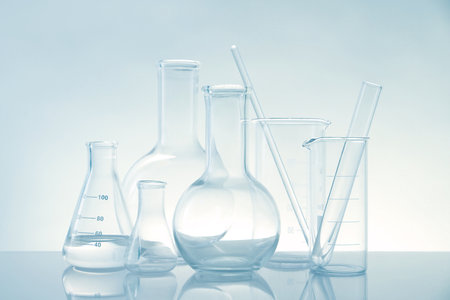 Laboratory glassware on mirror surface against light backgroundの写真素材