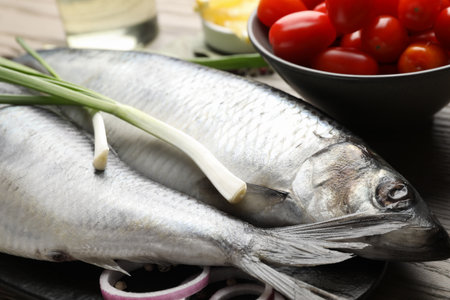 Salted herrings, spices and tomatoes on table, closeupの写真素材
