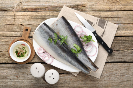 Tasty herring fillets with spices on wooden table, flat layの写真素材