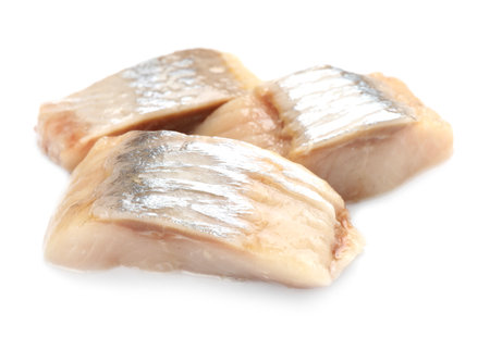 Pieces of delicious herring isolated on whiteの写真素材