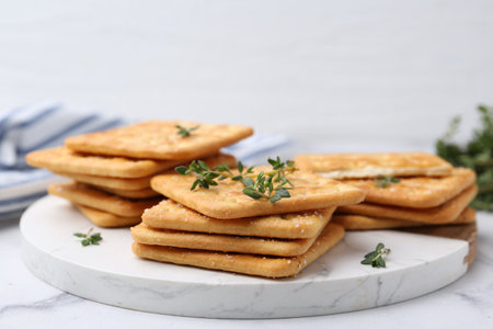 Tasty salty crackers with thyme on white marble table, closeupの写真素材