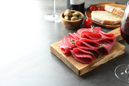 Slices of delicious sausage with thyme served on gray table. Space for textの写真素材