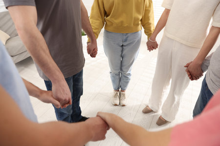 People holding hands during group psychotherapy session indoors, closeupの写真素材