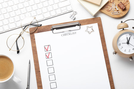 Checklist with marked checkboxes, stationery, glasses, coffee and computer keyboard on white table, flat layの写真素材