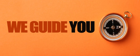 We Guide You text and compass on orange background, top view. Banner designの写真素材