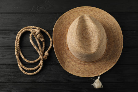 Cotton rope and straw hat on black wooden background, flat layの写真素材