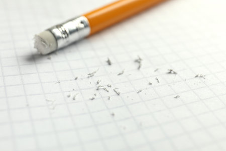Pencil with eraser and scraps on white sheet of paper, selective focusの写真素材