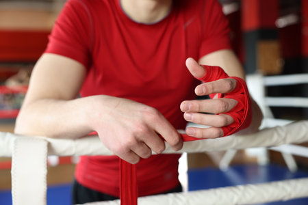 Man wrapping her hands on boxing ring, closeupの写真素材