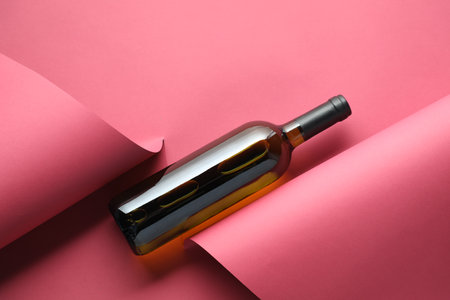 Bottle of tasty wine on pink background, top viewの写真素材