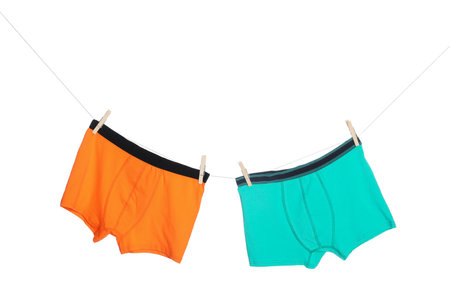 Comfortable men's underwear on clothes line against white backgroundの写真素材