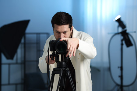 Man with professional video camera in studio