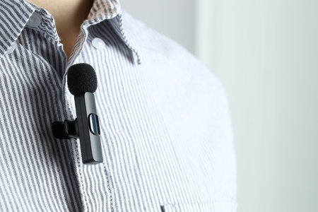 Man with lavalier microphone attached to his shirt on light gray background, closeupの写真素材