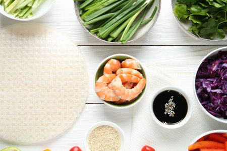 Rice paper sheets and different ingredients on white wooden table, flat layの写真素材